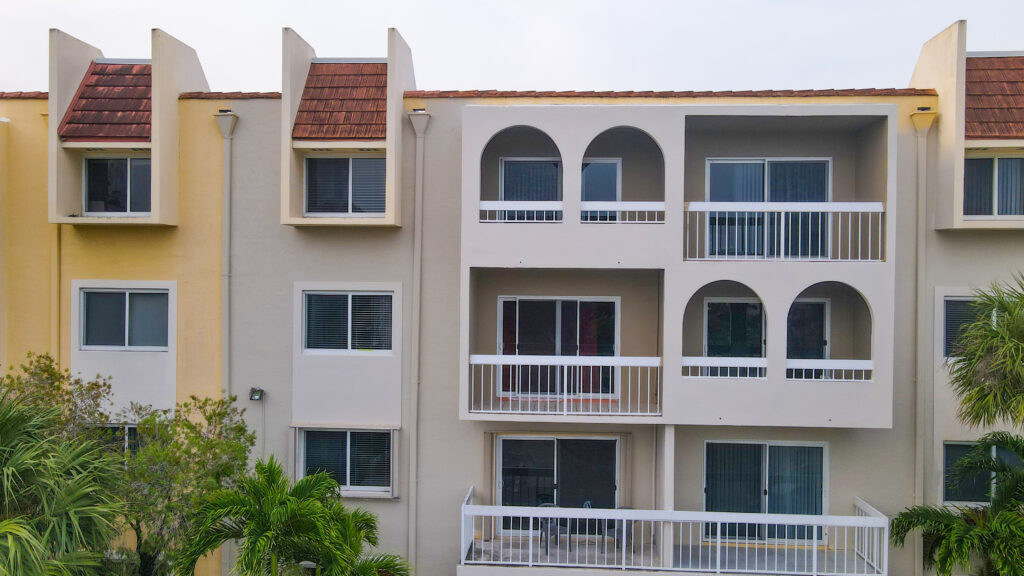 Condos with balconies and arched windows, showcasing Oratso Corporation's condominium projects in South Florida.