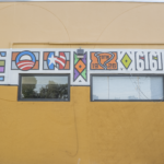 Colorful mural on a wall featuring abstract designs and symbols, representing cultural themes relevant to Oratso Corp's focus on cultural art centers.