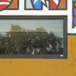 Colorful mural with cultural motifs above a window on a building, reflecting the commitment of Oratso Corp to cultural art centers in South Florida and Caribbean Islands.