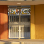 Colorful entrance with decorative stained glass and metal gates, representing cultural art centers by Oratso Corp.