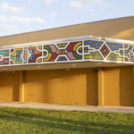 Cultural art center exterior featuring vibrant mural and yellow facade, highlighting Oratso Corp's community engagement in South Florida and Caribbean Islands.