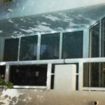Balcony view of a modern apartment featuring large glass windows and a sleek railing, showcasing the architectural design associated with Oratso Corporation's offerings.
