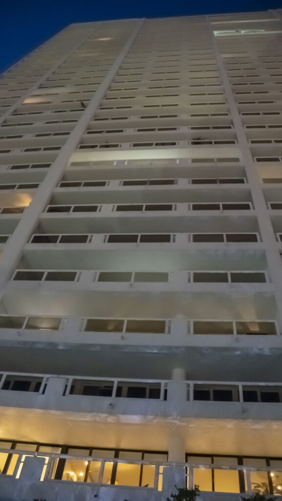 Modern apartment building exterior at night, showcasing multiple balconies and illuminated windows, representing Oratso Corporation's apartment offerings in Miami.