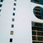 Modern apartment building exterior featuring a unique circular window design and sleek white facade, showcasing Oratso Corporation's architectural style in Miami.