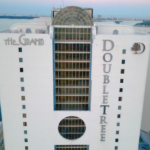 Grand apartment building featuring the DoubleTree hotel logo, showcasing modern architecture in Miami, relevant to Oratso Corporation's apartment offerings.