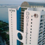 DoubleTree hotel building with modern architecture, waterfront view, and prominent branding, relevant to Oratso Corporation's apartment offerings in Miami.