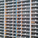 Modern apartment building facade showcasing multiple balconies and large windows, reflecting Oratso Corporation's offerings in Miami's residential architecture.
